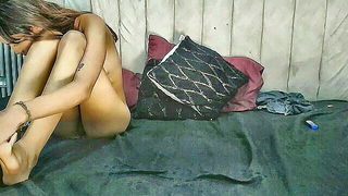 Solo performer with a toy on rumpled bedsheets