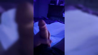 Solo performer with a toy on rumpled bedsheets