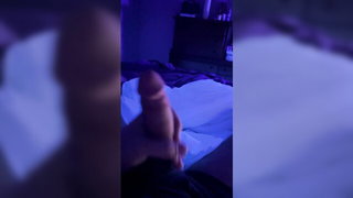 Solo performer with a toy on rumpled bedsheets