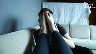 Amateur couple on a living room sofa in explicit scene