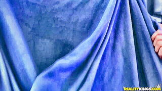 Couple on a patterned bedspread in an explicit scene