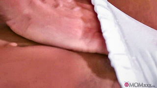 Couple on a patterned bedspread in an explicit scene