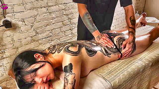 Explicit massage scene in a softly lit room