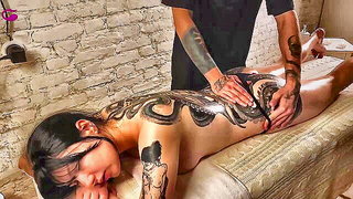 Explicit massage scene in a softly lit room