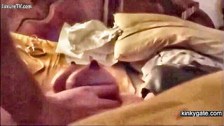 Couple on a made bed in an explicit scene