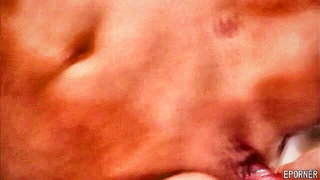 Couple on a made bed in an explicit scene