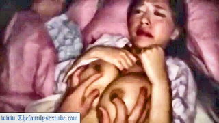 Couple on a made bed in an explicit scene