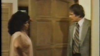 Couple mid-scene in a dim bedroom