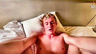 Solo performer with a toy on rumpled bedsheets