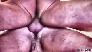 Couple on a made bed in an explicit scene