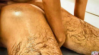 Couple on a patterned bedspread in an explicit scene