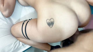 Couple on a made bed in an explicit scene