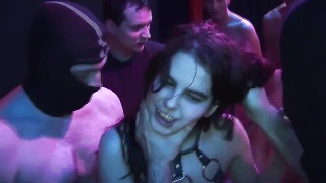Performers on a studio set under soft lighting in a Orgy Gangbang scene