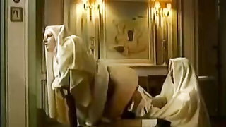 Studio set with performers in an explicit scene under bright lights