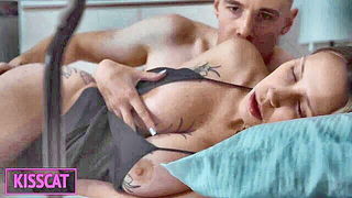 Couple on a made bed in an explicit scene