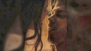 Couple on a made bed in an explicit scene