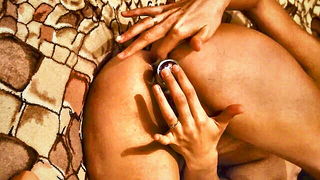 Couple on a patterned bedspread in an explicit scene