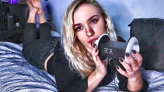 Solo performer with a toy on rumpled bedsheets