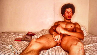 Couple on a patterned bedspread in an explicit scene
