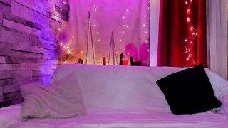 Couple on a made bed in an explicit scene
