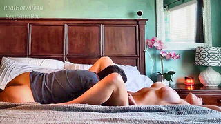Couple on a patterned bedspread in an explicit scene