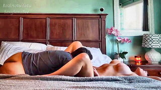 Couple on a patterned bedspread in an explicit scene