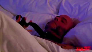 Couple on a patterned bedspread in an explicit scene