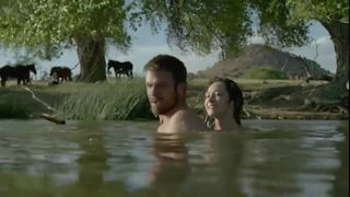 Couple on a made bed in an explicit scene