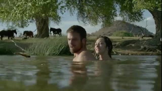 Couple on a made bed in an explicit scene