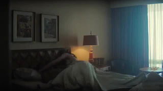 Solo performer with a toy on rumpled bedsheets