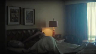 Solo performer with a toy on rumpled bedsheets