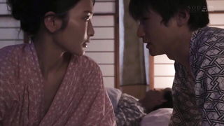 Couple on a made bed in an explicit scene