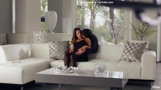 Amateur couple on a living room sofa in explicit scene
