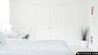Solo performer with a toy on rumpled bedsheets